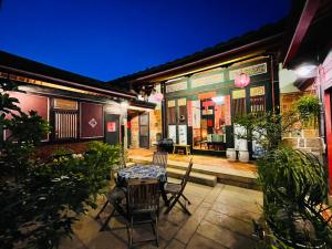 a patio with a table and chairs in front of a building at Grace Homestay in Jincheng