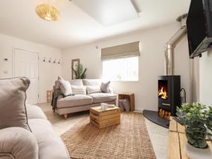 a living room with a couch and a fireplace at The Old Post Office in Helston