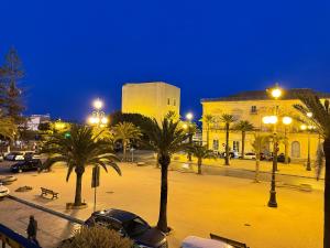 eine Stadtstraße mit Palmen und Gebäuden in der Nacht in der Unterkunft Appartamento Suite Galatea in Pozzallo