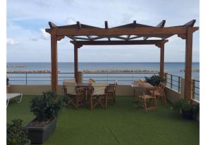 a patio with a table and chairs and the ocean at Xristinas Seaside Apartments in Kolymvari