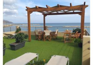 eine Terrasse mit einem Tisch, Stühlen und Meerblick in der Unterkunft Xristinas Seaside Apartments in Kolimvárion