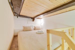niewielka sypialnia z łóżkiem i drewnianym sufitem w obiekcie Travelto Kazanski w Petersburgu