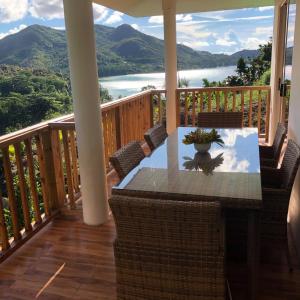a table on a balcony with a view of a lake at Mirella Villa Ocean View Villa in Praslin