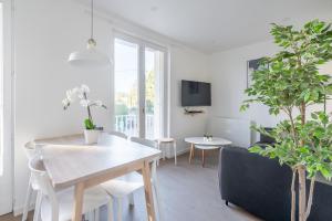 ein weißes Wohnzimmer mit einem Tisch und Pflanzen in der Unterkunft Welcome perche ! Appartements 3 étoiles à NOGENT le Rotrou in Nogent-le-Rotrou