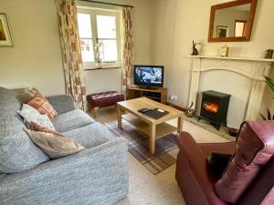 ein Wohnzimmer mit Couch und Kamin in der Unterkunft Derrybrook Cottage, Twin or Superking, Seven Springs Cottages in Cheltenham + 5 Fotos