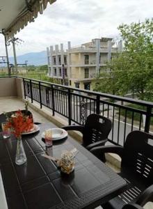 a table on a balcony with a view of a building at VILLA ELLI with free private Parking in Olympic Beach