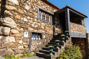 um edifício de pedra com escadas e uma janela em Quinta do Pereiro de Cima em Castelo de Paiva