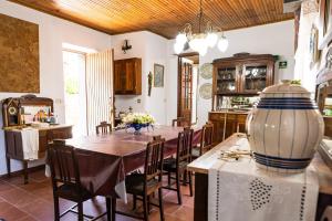 uma cozinha e sala de jantar com uma mesa e um vaso em Quinta do Pereiro de Cima em Castelo de Paiva
