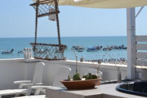 - une table avec un bol de plantes sur un balcon donnant sur la plage dans l'établissement SottoSopra, à Margherita di Savoia