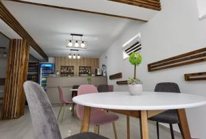 una sala da pranzo con tavolo e sedie bianchi di Casa Sima a Curtea de Argeş