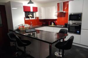 una cucina con armadi rossi e piano di lavoro nero di The Cottage - Hot Tub - nr Glasgow - self check-in a Coatbridge