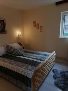 een groot bed in een slaapkamer met een raam bij Vacation house Dora in Malinska