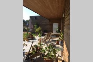 a patio with chairs and potted plants at Maison individuelle avec terrasse proche de Bâle in Schlierbach