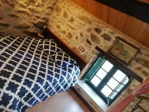 a bedroom with a bed and a window at Molino de Louzao in Palas de Rei