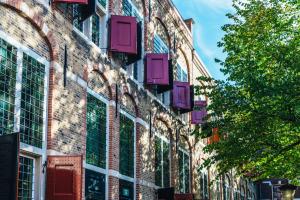 a brick building with colorful windows on the side of it at Relais & Châteaux Weeshuis Gouda in Gouda