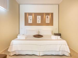 um quarto com uma cama grande e lençóis brancos em Giglio di Chia - Your Dream Holiday em Domus de Maria