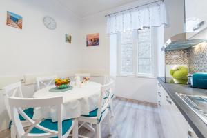 uma cozinha branca com uma mesa e cadeiras brancas em Old Town Finest em Dubrovnik