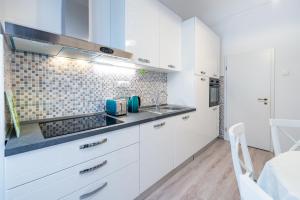 a kitchen with white cabinets and a sink at Old Town Finest in Dubrovnik