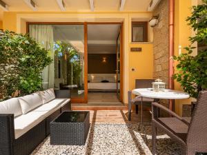 a patio with a white couch and a table at Giglio di Chia - Your Dream Holiday in Domus de Maria