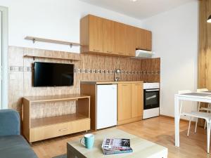 a kitchen with wooden cabinets and a white refrigerator at Laurel Apartments in Bar