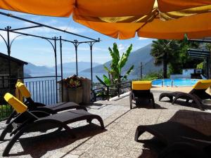 - un groupe de chaises et un parasol à côté de la piscine dans l'établissement Rosato, à Gravedona