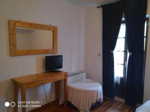 a room with a desk with a television and a window at XENONAS SOULIOU in Samonída