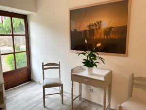 een kamer met een tafel, een stoel en een plant bij Maison Belles Pierres in Montagny-lès-Beaune