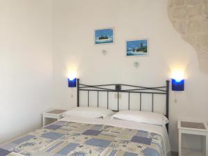 a bedroom with a bed and two lights on the wall at Zimmer Camere in Sirolo