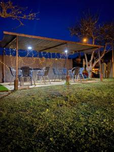 a table and chairs under a pavilion at night at Albergue Vintecatro in Caldas de Reis