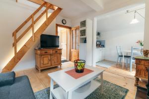 a living room with a table and a tv at Fürstenstüberl in Grundlsee