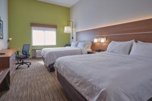 ein Hotelzimmer mit 2 Betten und einem Schreibtisch in der Unterkunft Holiday Inn Express Hotel and Suites Akron South-Airport Area, an IHG Hotel in Akron