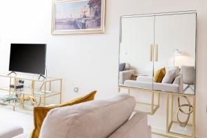 
a living room filled with furniture and a tv at 10 Saint James - By Luxury Apartments in Cheltenham
