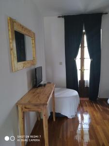 a room with a desk with a bed and a window at XENONAS SOULIOU in Samonída