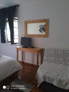 a bedroom with a bed and a desk with a television at XENONAS SOULIOU in Samonída