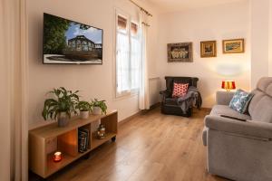 a living room with a couch and a chair at Can Prat Loft in Ripoll