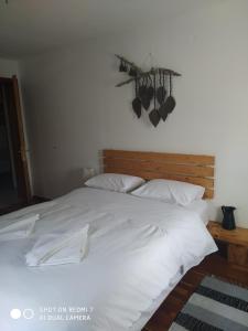 1 cama blanca grande con sábanas y almohadas blancas en XENONAS SOULIOU, en Samonída