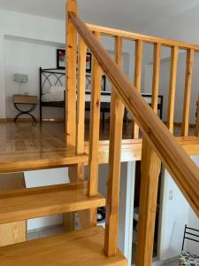 a wooden staircase in a room with a bed at Glaros Guesthouse in Hydra