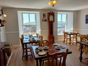 a dining room with a table and a grandfather clock at Murphy's Guesthouse in Dingle