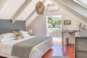 1 dormitorio con 1 cama y balcón en The Barn On 62 - Cottages, en Montagu
