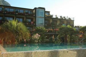 un hôtel avec une piscine en face d'un bâtiment dans l'établissement Hotel Alexander, à Limone sul Garda