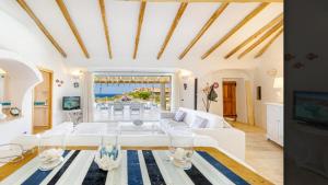 sala de estar con sofá blanco y mesa en Sardinia Family Villas - Villa MariaPia with private pool and seaview, en Porto Cervo