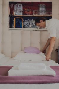 a man is making a bed in a room at Herberg Sint Petrus in Hilvarenbeek