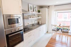 uma cozinha com armários brancos e um forno de aço inoxidável em Apartments in Dingle Town Center em Dingle