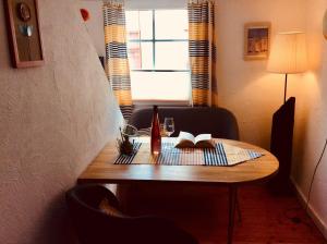 einen Tisch in einem Zimmer mit einem Buch und einem Fenster in der Unterkunft Winzerhäuschen, Weingut Th. Müller in Reil