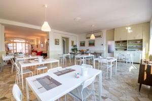 restauracja z białymi stołami i krzesłami oraz kuchnią w obiekcie B&B Belvedere w mieście Colico +10 zdjęć