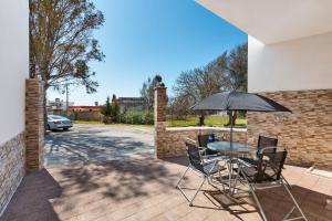 a table and chairs with an umbrella on a patio at Villino Vanessa by BarbarHouse in Torre Lapillo
