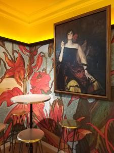 a painting of a woman on a wall with stools at Pestana Plaza Mayor Madrid in Madrid