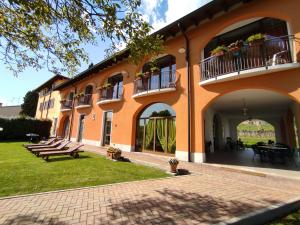 ein orangefarbenes Gebäude mit Bänken im Hof in der Unterkunft Agriturismo La Vigna in Colà di Lazise