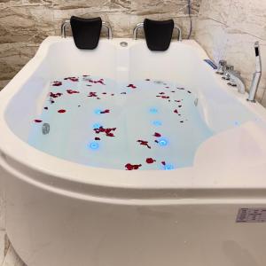 a white bath tub filled with red confetti at فندق حديقة القصور in Şāmitah