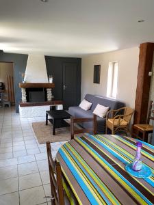een woonkamer met een bank en een woonkamer met een open haard bij Chez pépé in Arromanches-les-Bains